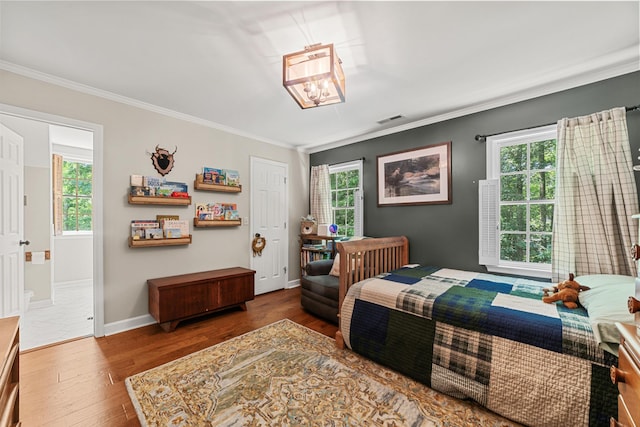 bedroom featuring ensuite bathroom, dark hardwood / wood-style flooring, and crown molding