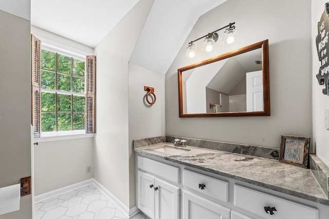 bathroom featuring vaulted ceiling, tile patterned flooring, a healthy amount of sunlight, and vanity