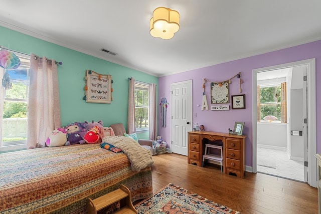 bedroom with crown molding, hardwood / wood-style floors, and multiple windows