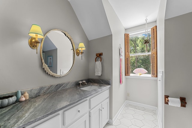 bathroom featuring tile patterned floors, vanity, and lofted ceiling