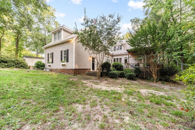 rear view of house with a lawn and a wooden deck