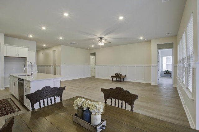 dining room with ceiling fan, sink, and light hardwood / wood-style floors