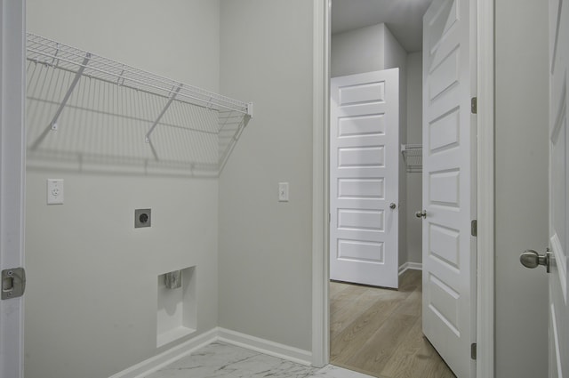 washroom with hookup for an electric dryer and light hardwood / wood-style flooring