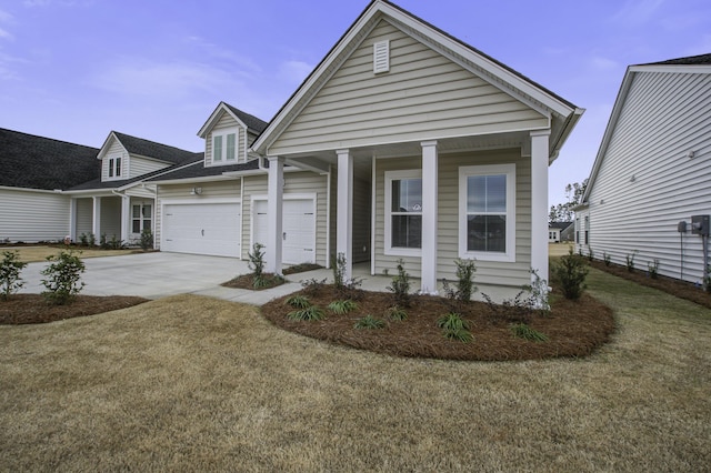 view of front of home featuring covered porch, a front yard, and a garage