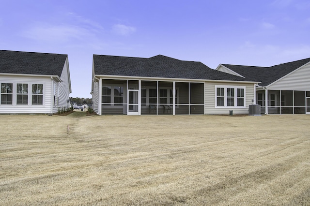 rear view of house featuring central air condition unit and a sunroom