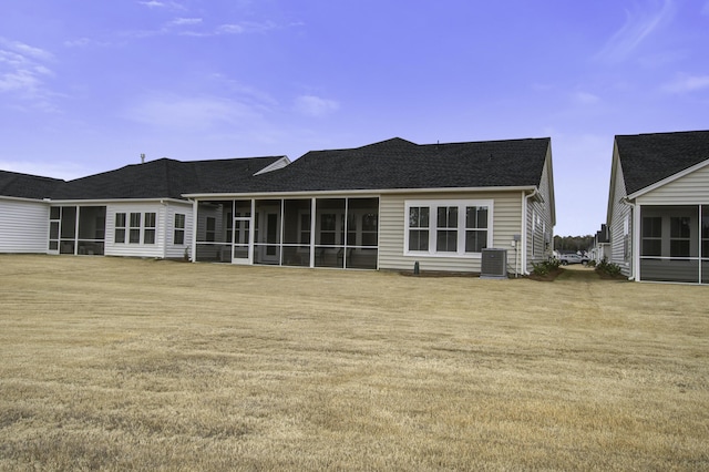 rear view of house with central AC and a sunroom