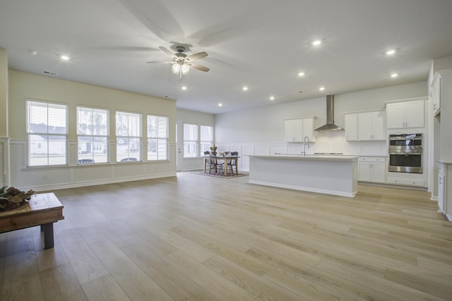 interior space with ceiling fan, sink, and light wood-type flooring