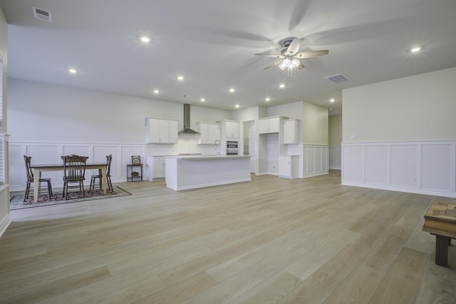 unfurnished living room featuring ceiling fan and light wood-type flooring