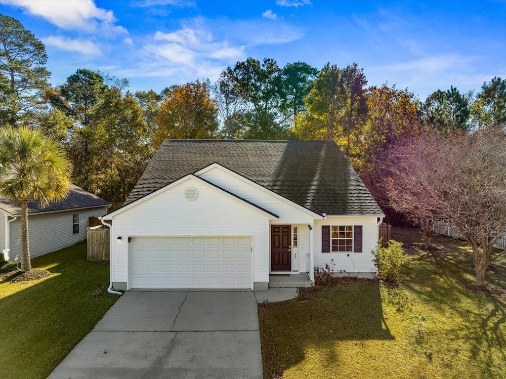 view of front of home with a front yard and a garage