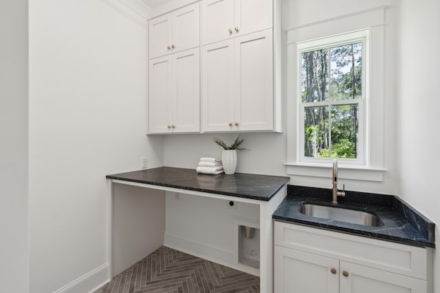 kitchen with sink, dark parquet flooring, a wealth of natural light, and white cabinetry