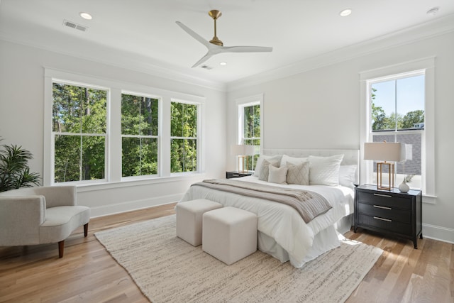 bedroom with ornamental molding, light hardwood / wood-style floors, and ceiling fan