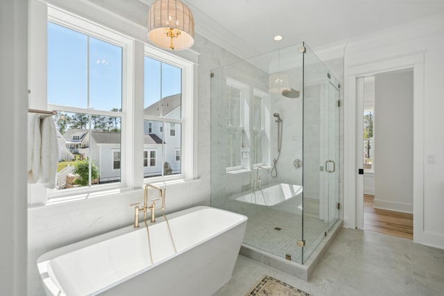 bathroom with a freestanding tub, a stall shower, recessed lighting, crown molding, and baseboards