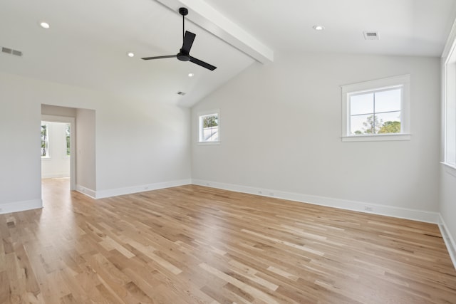 unfurnished room featuring plenty of natural light, light hardwood / wood-style flooring, lofted ceiling with beams, and ceiling fan