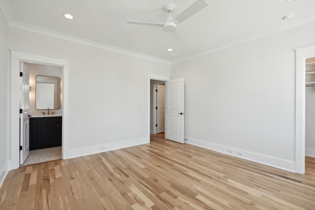 unfurnished bedroom with ceiling fan, ensuite bathroom, sink, light wood-type flooring, and crown molding