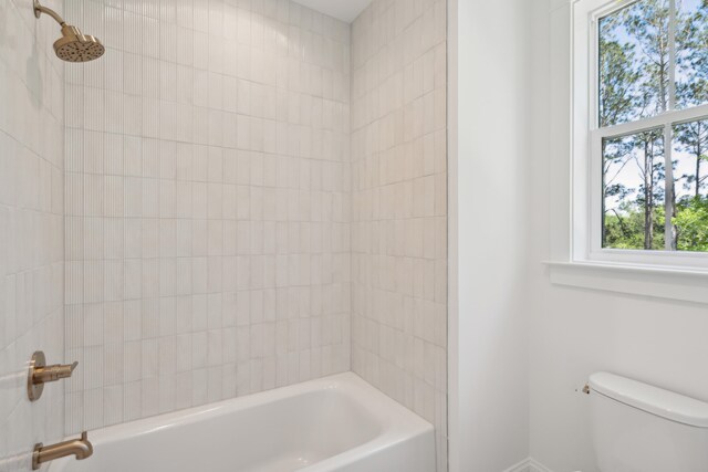 bathroom with tiled shower / bath and toilet