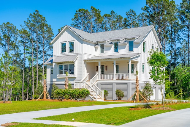 view of front of property with driveway, a porch, stairs, a front lawn, and board and batten siding