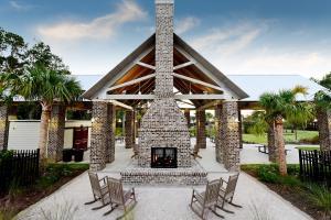 view of patio with a gazebo, an outdoor brick fireplace, and fence