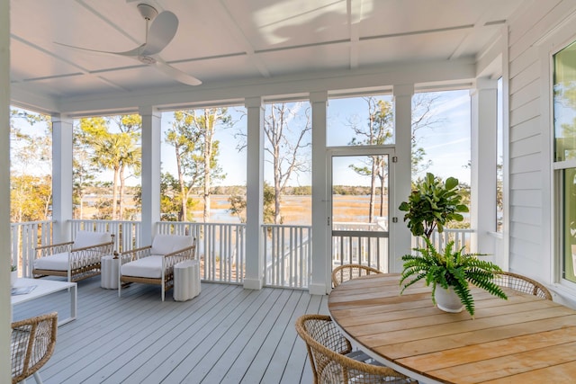 sunroom featuring a water view, ceiling fan, and plenty of natural light