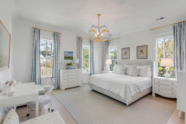 bedroom featuring crown molding, hardwood / wood-style floors, and an inviting chandelier