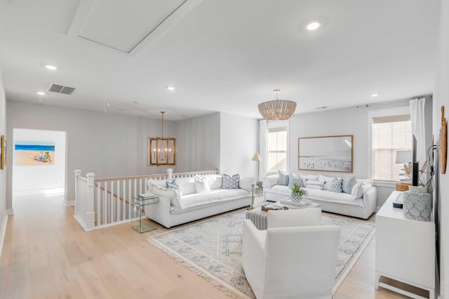 living room with an inviting chandelier and light hardwood / wood-style floors