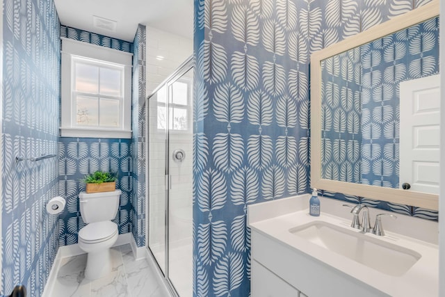 bathroom featuring vanity, a shower with shower door, and toilet