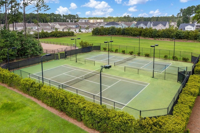 view of tennis court with a yard