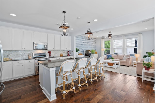 3203 Moonlight Dr, Charleston, SC 29414 - kitchen featuring appliances with stainless steel finishes, a sink, backsplash, a breakfast bar, and recessed lighting