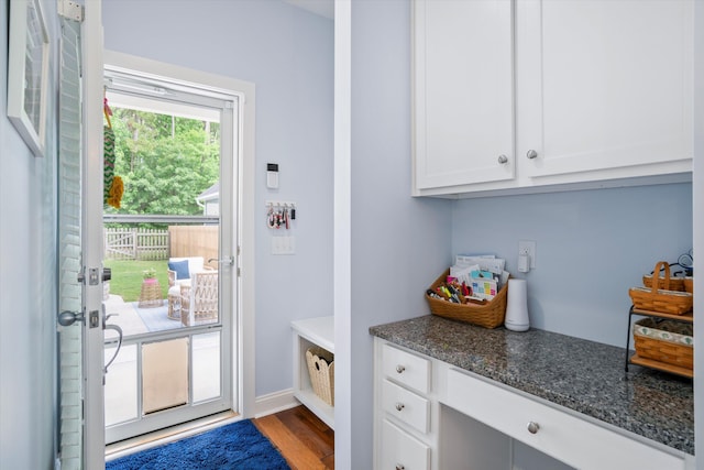 3203 Moonlight Dr, Charleston, SC 29414 - kitchen with white cabinetry, dark stone counters, wood finished floors, and baseboards