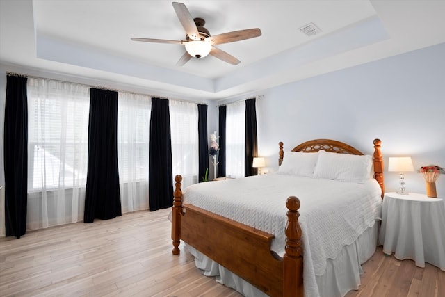3203 Moonlight Dr, Charleston, SC 29414 - bedroom with a tray ceiling, light wood-style flooring, and a ceiling fan