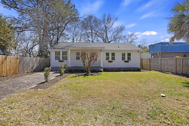 view of front of property featuring fence private yard and a front lawn