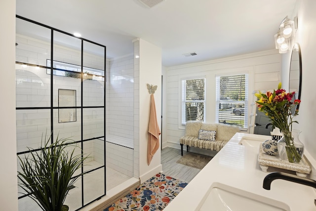 bathroom with visible vents, a walk in shower, wood finished floors, and double vanity