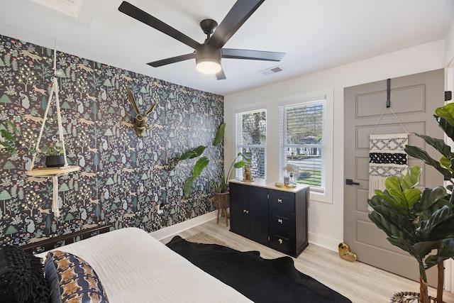 bedroom featuring light wood finished floors, visible vents, ceiling fan, and baseboards