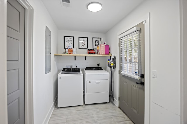 clothes washing area featuring visible vents, baseboards, electric panel, laundry area, and separate washer and dryer