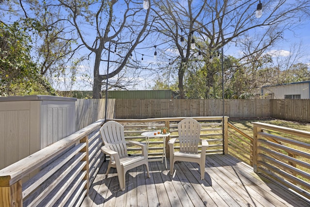 wooden deck with a fenced backyard