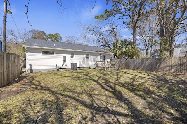 back of house with a wooden deck, cooling unit, a lawn, and a fenced backyard