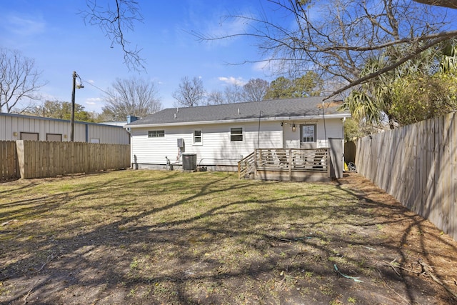 rear view of house featuring central AC unit, a lawn, a fenced backyard, and a deck