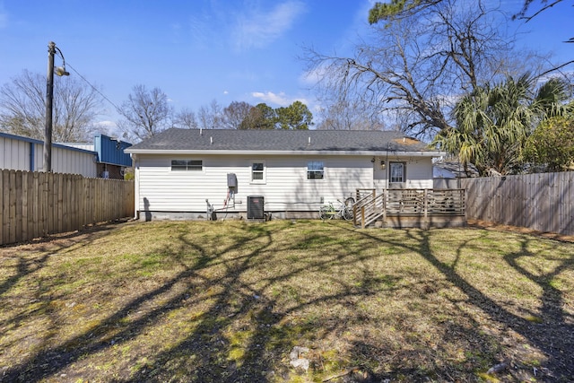 rear view of house with a yard, a deck, central AC, and a fenced backyard