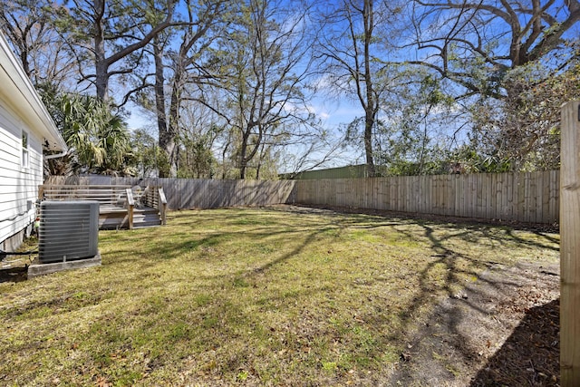 view of yard with central AC unit and a fenced backyard