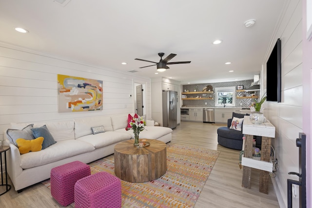 living room with recessed lighting, light wood-style flooring, and a ceiling fan