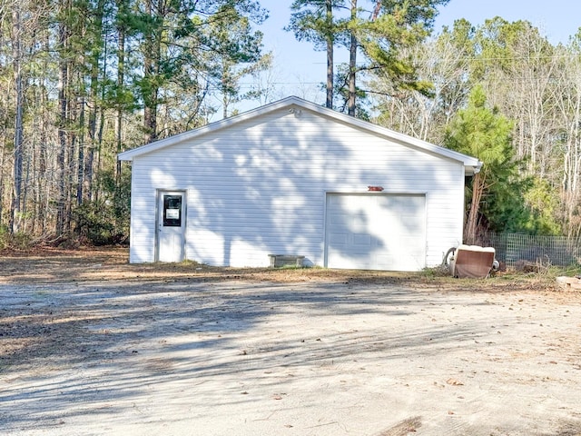 detached garage featuring fence