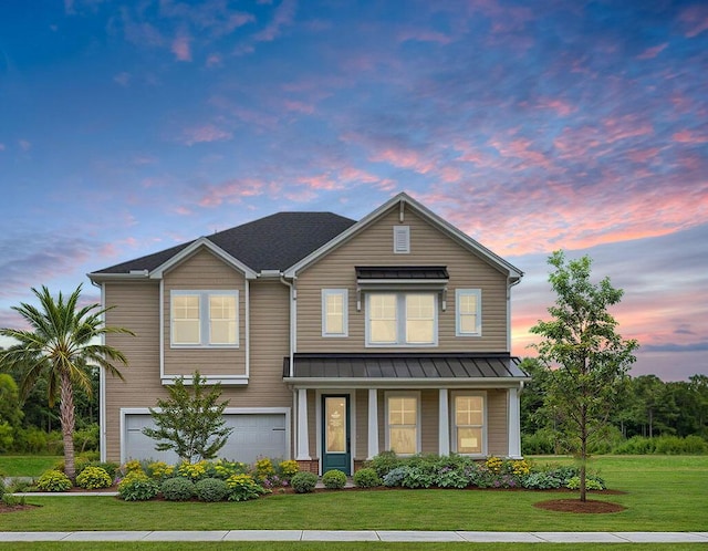 view of front of property featuring a garage and a lawn