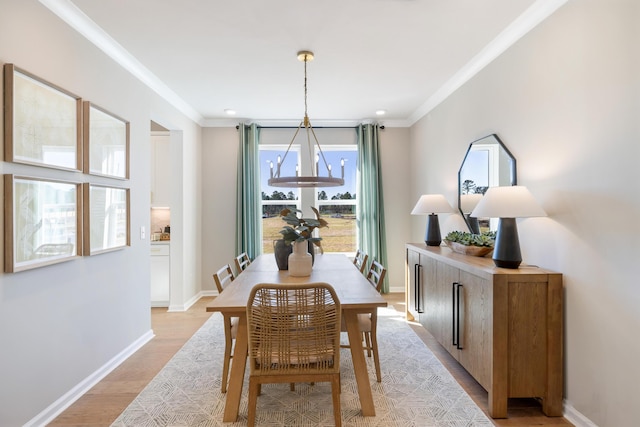 dining space featuring ornamental molding, an inviting chandelier, and light hardwood / wood-style flooring