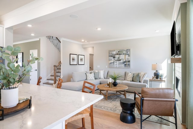 living room featuring crown molding and light hardwood / wood-style flooring