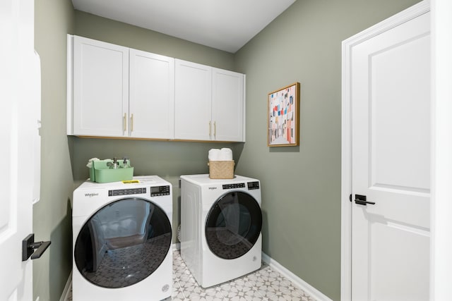 washroom featuring cabinets and washer and clothes dryer