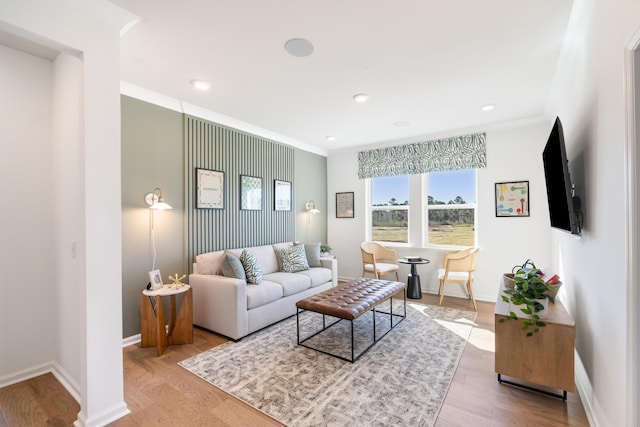 living room featuring crown molding and light hardwood / wood-style flooring