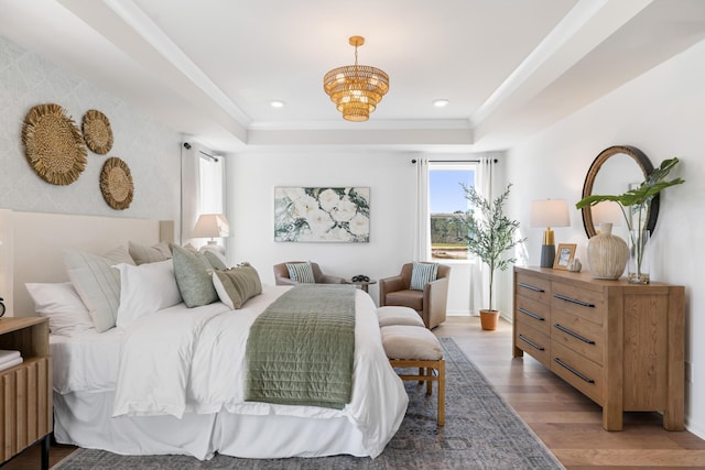 bedroom with crown molding, a tray ceiling, and hardwood / wood-style flooring