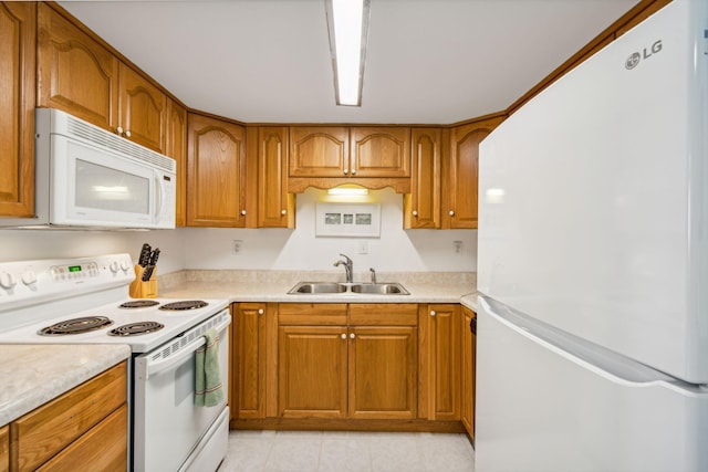 kitchen featuring light tile patterned flooring, sink, and white appliances