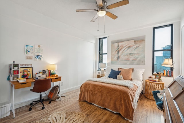 bedroom with multiple windows, ceiling fan, and light wood-type flooring