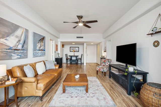 living room featuring ceiling fan and light hardwood / wood-style floors