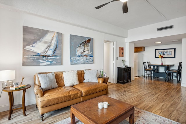 living room featuring ceiling fan and light hardwood / wood-style flooring